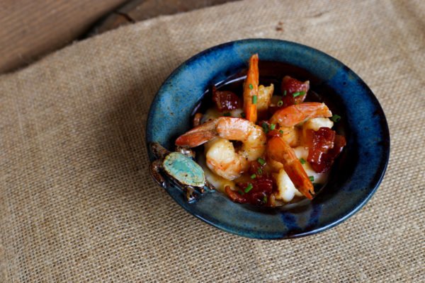 Image of Ladle grits into bowl, top with shrimp, pan sauce, candied...