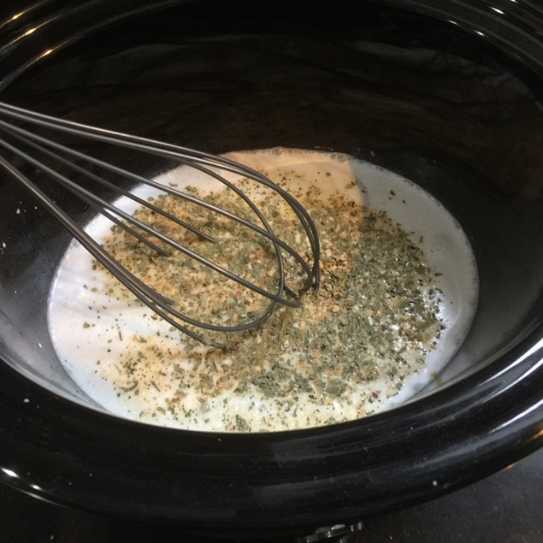 Image of Pour coconut milk into the slow cooker. Add Thai seasoning and whisk together.