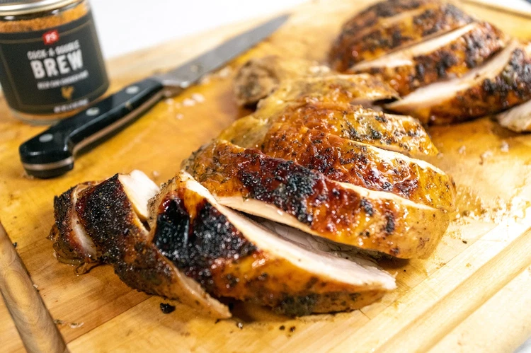 Image of Remove turkey from the grill and transfer to a carving board. Let rest 20 minutes before carving and serving warm with beer braised onions and pan jus.
