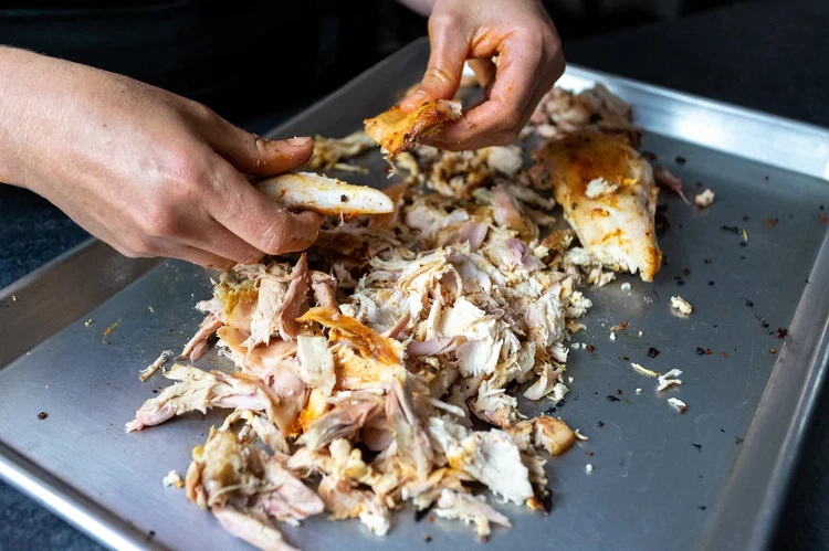Image of Section the chicken into leg, thigh, and breast, then remove the skin, and pull the chicken. 