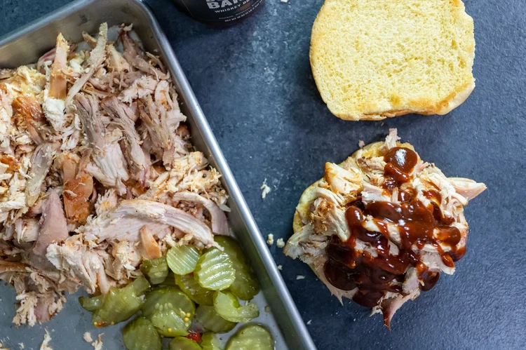 Image of Place pulled chicken in a mixing bowl, then toss with Bourbon Barrel Sauce.  Serve warm for a sandwich, or chilled on a salad.