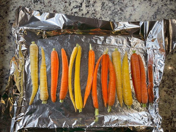 Image of On a baking sheet, spread out a layer of tinfoil and place the carrots on it. 