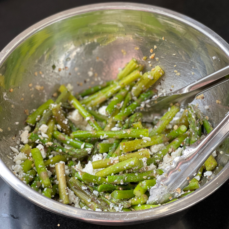 Image of Crumble the feta over the asparagus and add a pinch of Dash of Desperation. Toss together with tongs and serve chilled.
