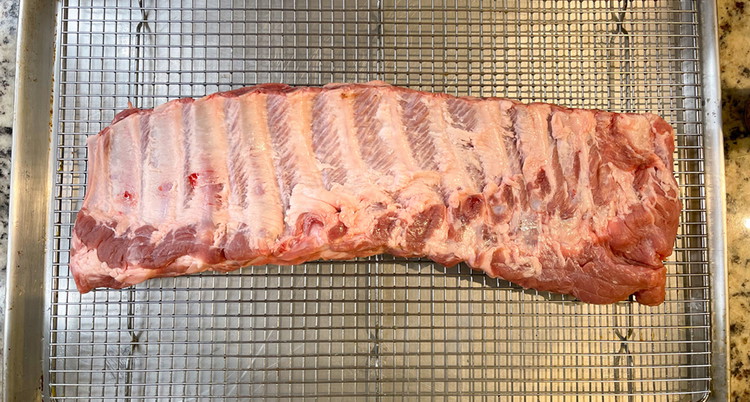 Image of Prepare the ribs by removing the silver skin membrane. The s Direction Prepare the ribs by removing the silver skin membrane. The silver skin can be easily removed by working a butterknife under the membrane and creating a gap where...