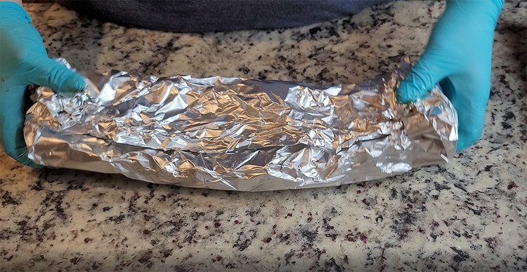 Image of Wrap into a tent like shape, folding the tin foil along the center seem. Curl the ends like a package and return the ribs to the smoker, meat side down (seem side up) for another 2 hours.