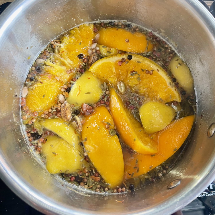 Image of Add the sugar, water and cut citrus. Mix everything well and bring to a simmer over low heat.