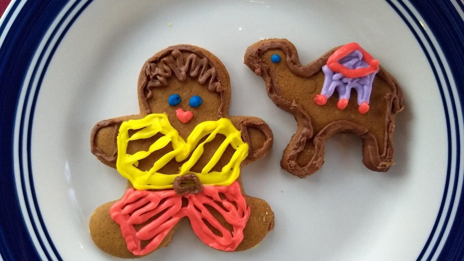 Gingerbread man cookie on a plate with a cup of coffee.