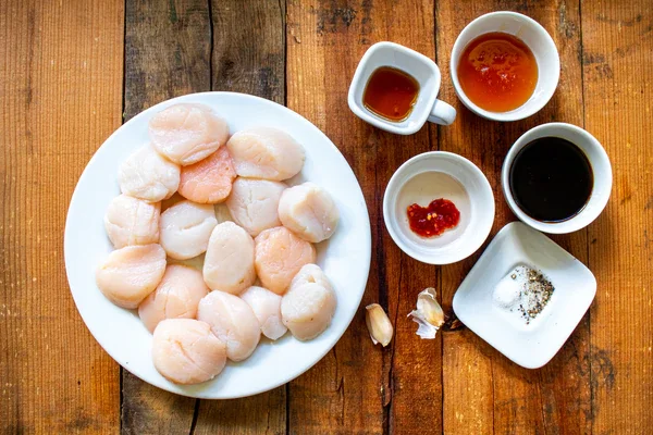 Image of Season the scallops with salt and ground black pepper.