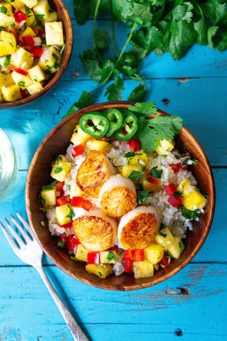 Image of Plate the coconut rice, pineapple salsa, and the scallops. Garnish...