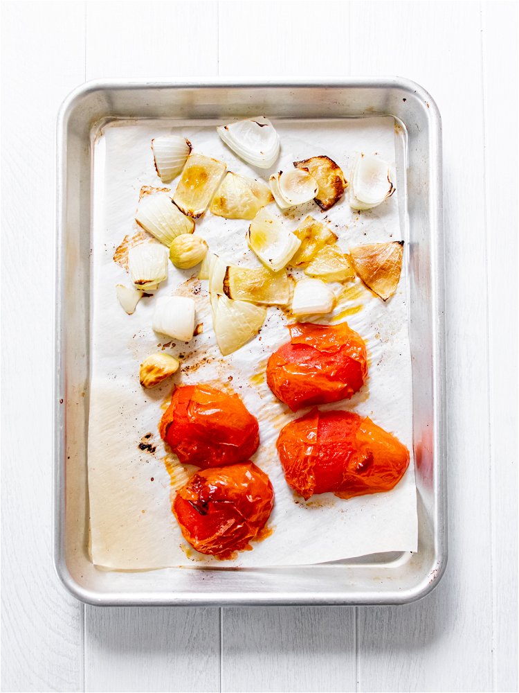 Image of Place tomatoes and onion on baking sheet and drizzle with...