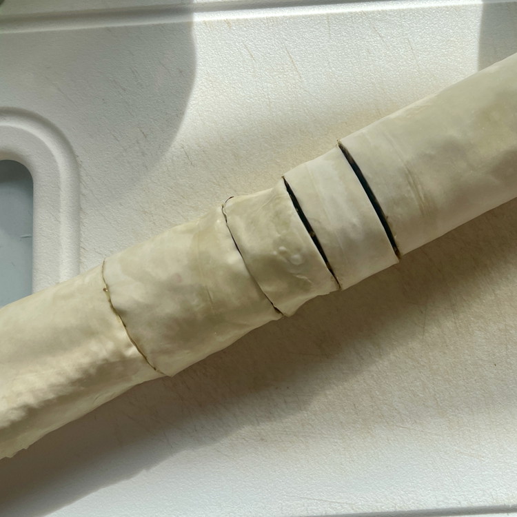 Image of Cut the roll into 16 equal pieces and brush the roll completely around with melted butter.