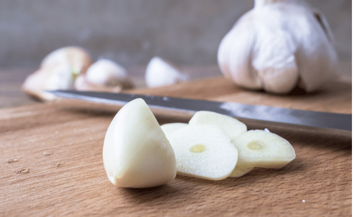 Image of Now peel your garlic cloves and slice them in half,...