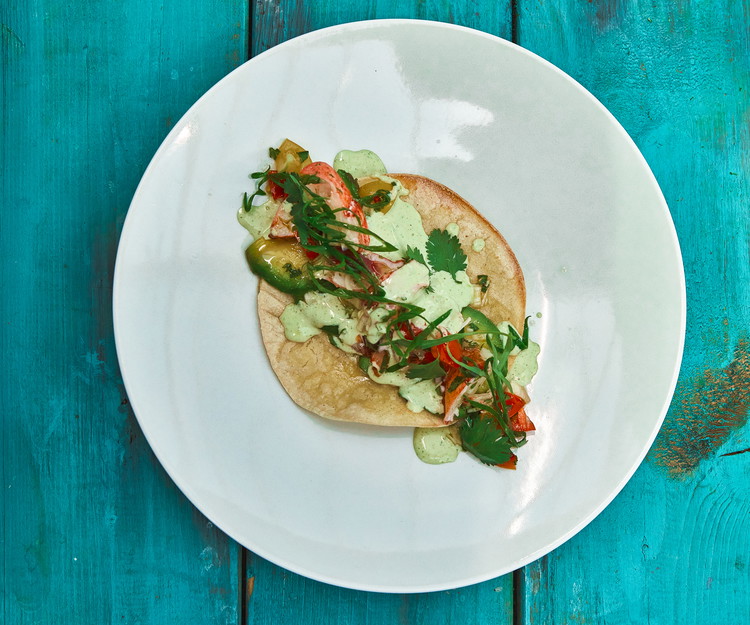 Image of Montez les tacos avec une base d'avocat au fond, des morceaux de homard, une bonne cuillère de salsa, quelques pointes d'aïoli et quelques feuilles de coriandre fraîche.