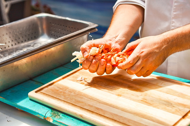 Image of À l'aide d'un linge de cuisine, détachez la grosse pince du corps du homard et replongez-la dans l'eau bouillante pour 3 minutes de cuisson supplémentaires.