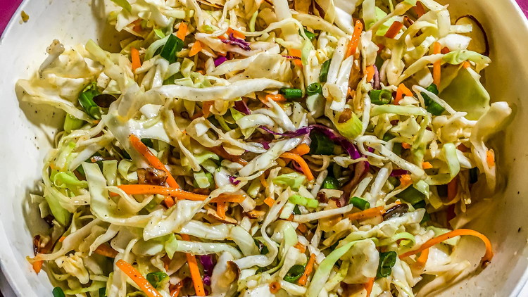 Image of In a bowl, add slaw, green onions, and almonds. 