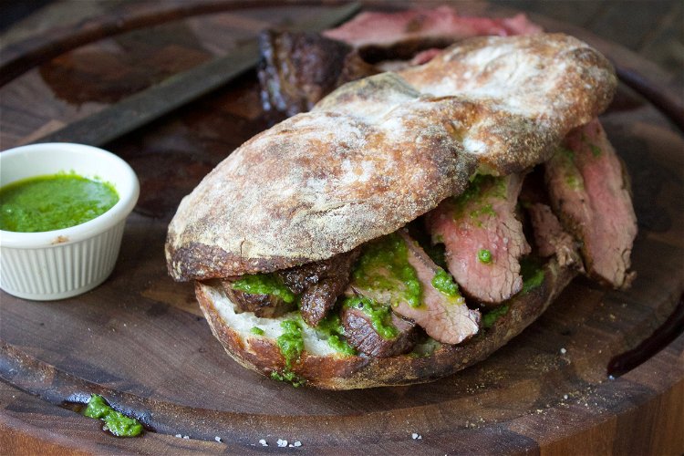 Image of Slice steak against the grain and assemble sandwich.