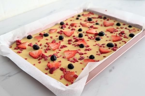 Image of Pour the batter into the tray and sprinkle the berries...
