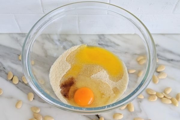 Image of Add in the egg, vanilla, melted butter and almond essence.