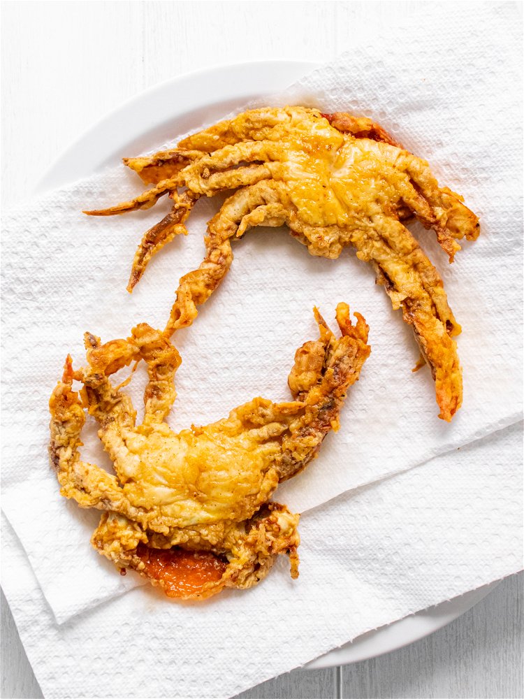 Image of Carefully place crabs in hot oil using tongs and fry...