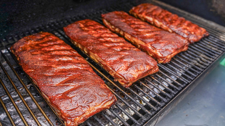 Image of When your ribs are done, remove from foil and apply Blues Hog Original Honey Glaze. Transfer back to the grill for about 5 minutes or until the glaze is tacky.