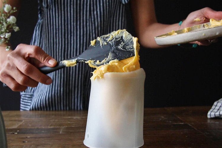 Image of Use a tall glass to prop the piping bag open...