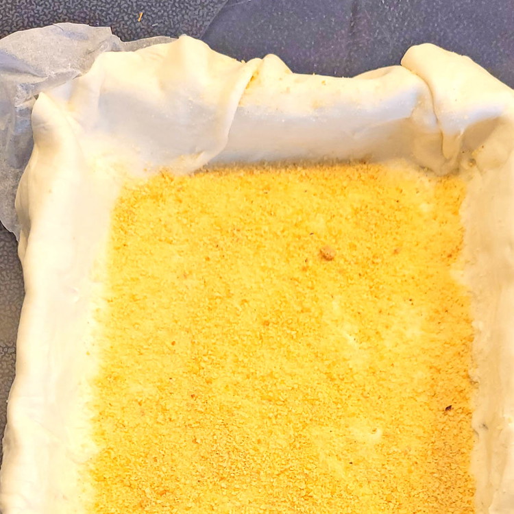 Image of auf den Blätterteig das Paniermehl gleichmässig verstreuen