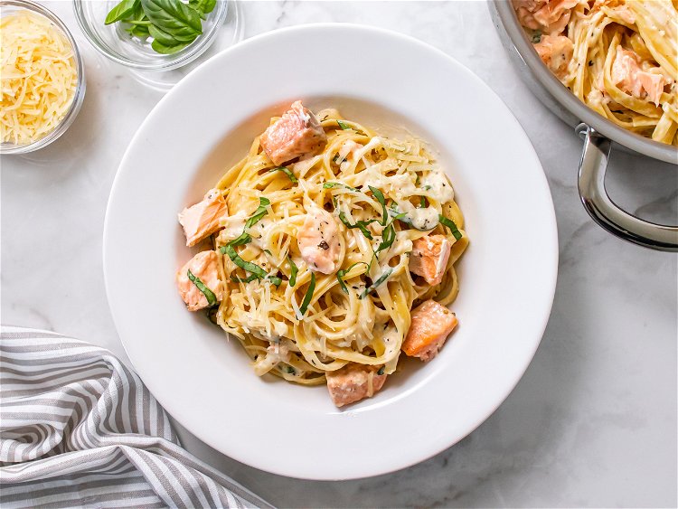 Image of Toss cooked fettuccine noodles in sauce to coat. Add salmon...