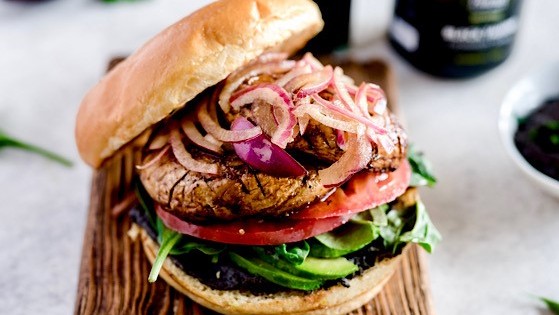 Image of Champignon-Burger mit schwarzem Bohnen-Hummus und eingelegten Zwiebeln