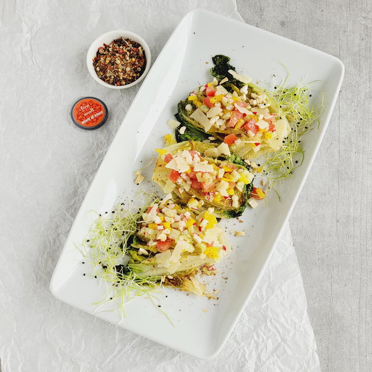 Image of Zum Anrichten legst du die Lattichhälften mit der Schnittfläche nach oben auf eine Platte. Darüber verteilst du grosszügig das Gemüsetartare, die Parmesanspäne und die gerösteten Cashewnüsse. Mit der frisch gemahlenen Gewürzmischung Fire wall verleihst du dem lauwarmen Lattich mit Gemüsetartare...