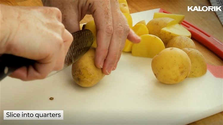 Image of Wash potatoes and slice them in half and into quarters...