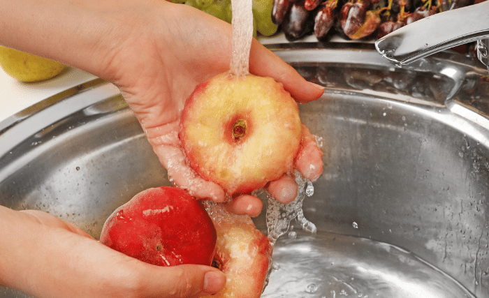 Image of Wash your peaches thoroughly under running water by gently rubbing...