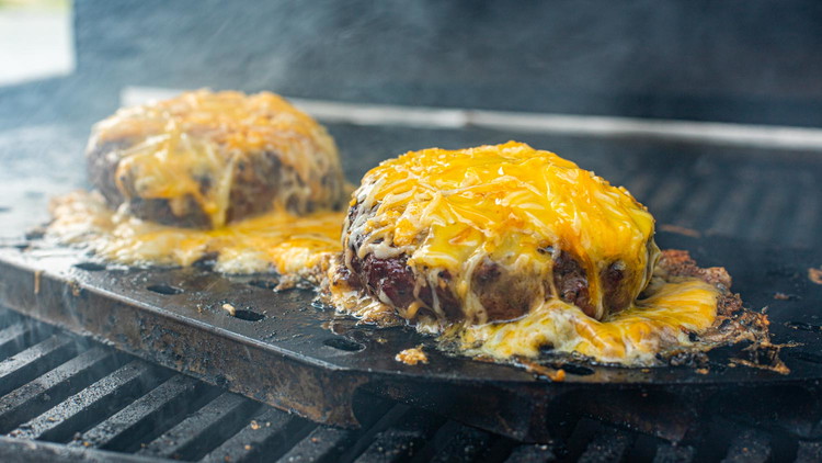 Image of When approaching the end of desired doneness, remove burgers from direct heat and cover with 1/4 cup shredded cheese, letting the cheese surround the burger. Cover the grill and let cheese fully melt. 