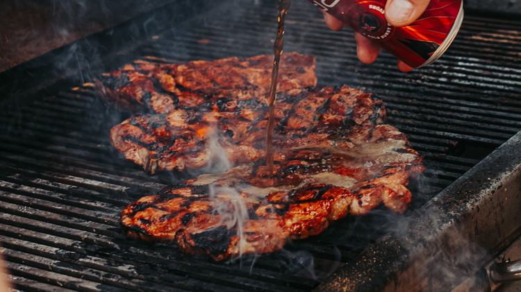 Image of While your steaks are searing, baste your steaks with your favorite cola product.