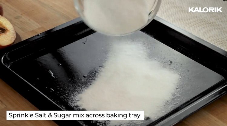 Image of Pour salt/sugar mix onto a baking pan and rest fruit,...