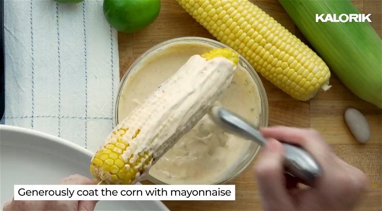 Image of Roll mayonnaise coated corn into the cotija cheese and lightly...