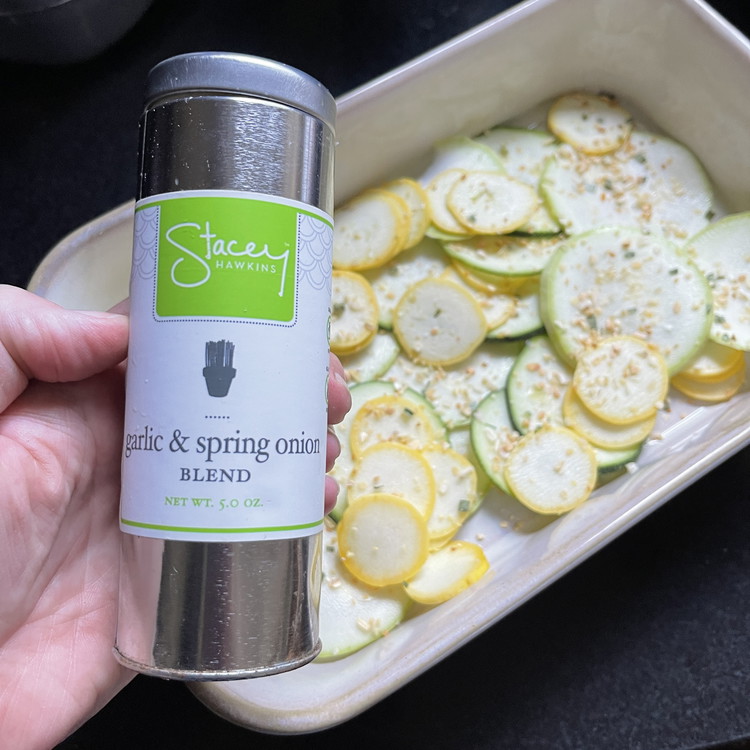 Image of Place a thin layer of squash (and onion)  in the bottom of a 9 x 12 baking dish. Sprinkle with a little Garlic and Spring Onion Seasoning. Repeat with 1-2 more layers of squash until all the vegetables are used.