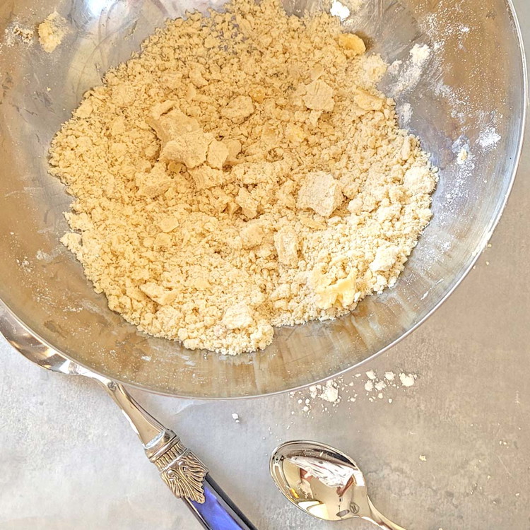 Image of Kratze aus der anderen Hälfte der Vanilleschote das Mark und vermische es mit der Butter in der Mehlmischung. Knete von Hand so lange, bis sich kleine Krümel bilden