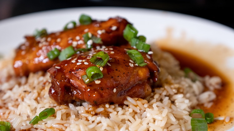 Image of Serve chicken thighs over rice and garnish with sesame seeds and green onion. 