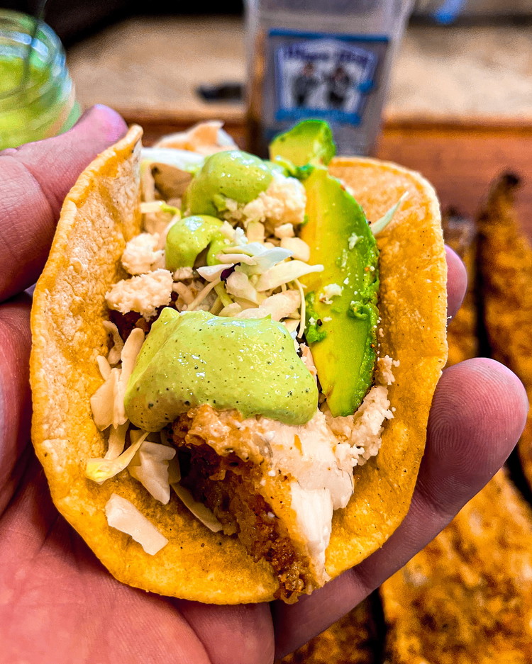 Image of Top with cabbage, avocado, queso fresco and creamy cilantro sauce.