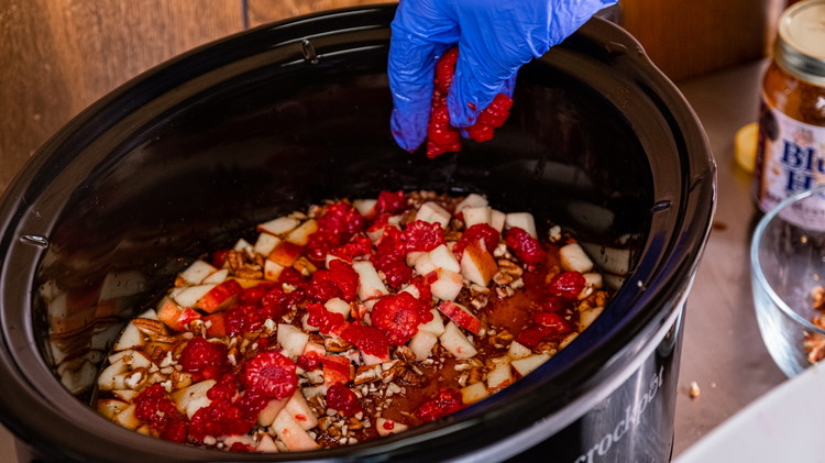 Image of Top the pork with the apples, pecans, and about half of your raspberries. You'll want to save the rest as a garnish. 