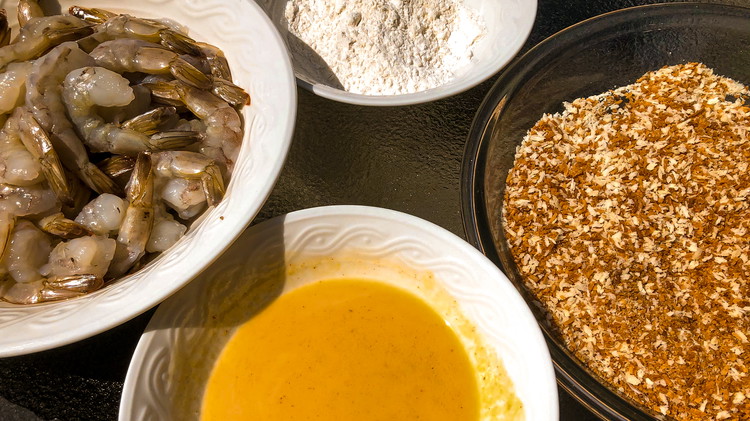 Image of Arrange dredge bowls in this order: flour dredge, milk dredge, coconut dredge, baking sheet with parchment paper.