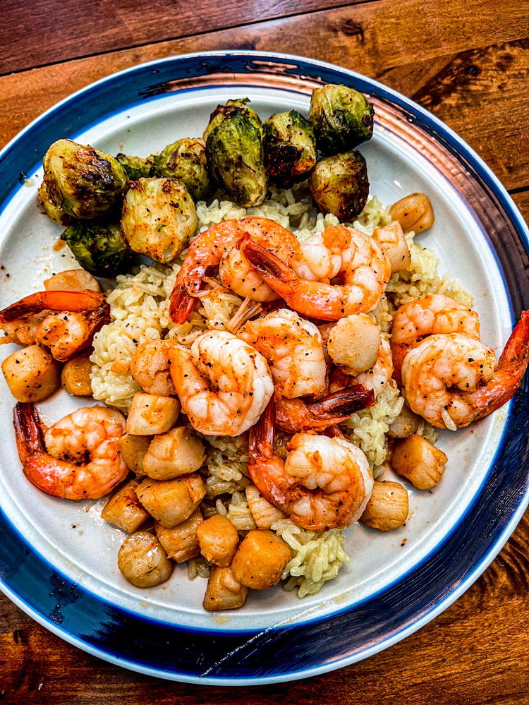 Image of Add brussel sprouts to the skillet with shrimp and scallops. Season with both Blues Hog seasonings and cover to help the brussel sprouts cook through. Stir occasionally to make sure each side gets cooked. This should take about 10 minutes.