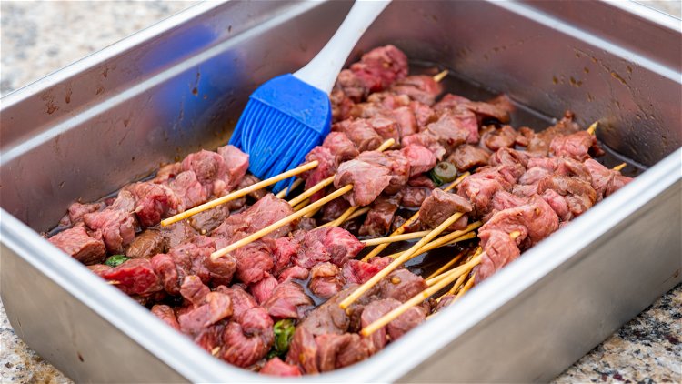 Image of In a gallon bag or large dish, cover the skewers...