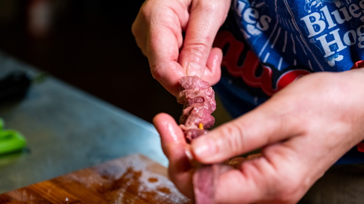 Image of Cut the sirloin steak into 1/4 inch strips and green onions into inch-long sections. Weave the strips of beef onto skewers. Add a bit of greed onion on the skewers along with sirloin strip. 