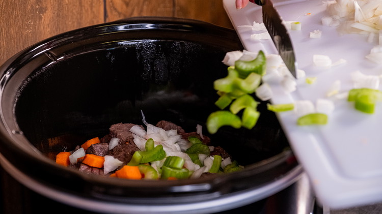 Image of Transfer beef over to the slow cooker. Add in the vegetables (onions, carrots, and celery) into the pot. Pour in beef broth, wine, tomato paste, and Worcestershire sauce. Add in the herbs and seasonings. Give the pot a good stir.