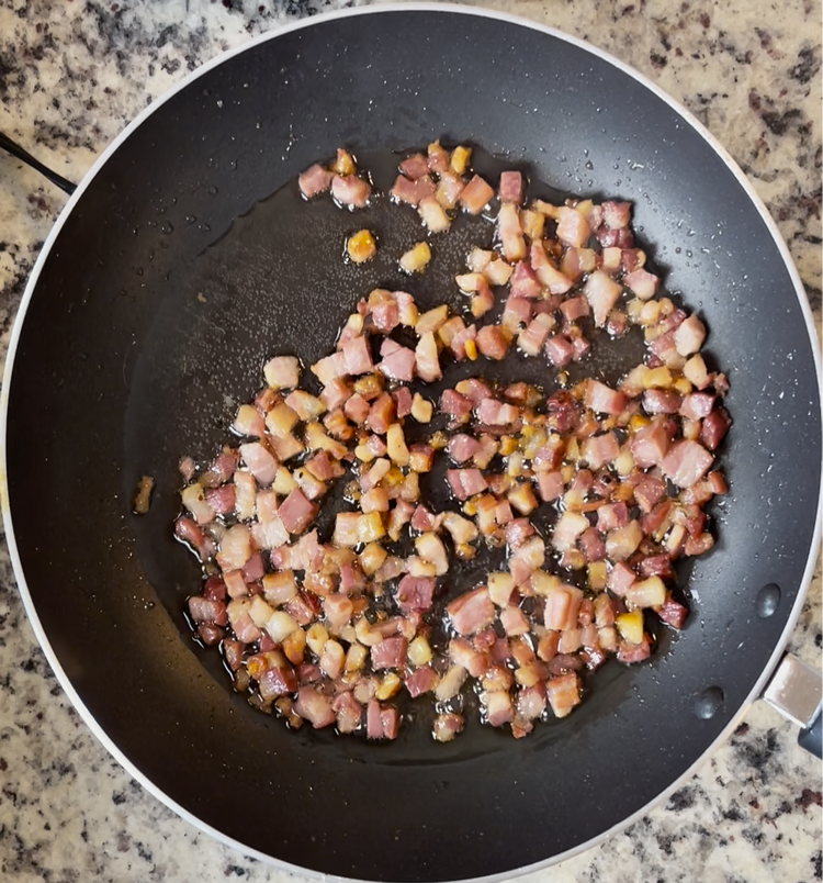 Image of In a large skillet over medium heat, render pancetta down. 