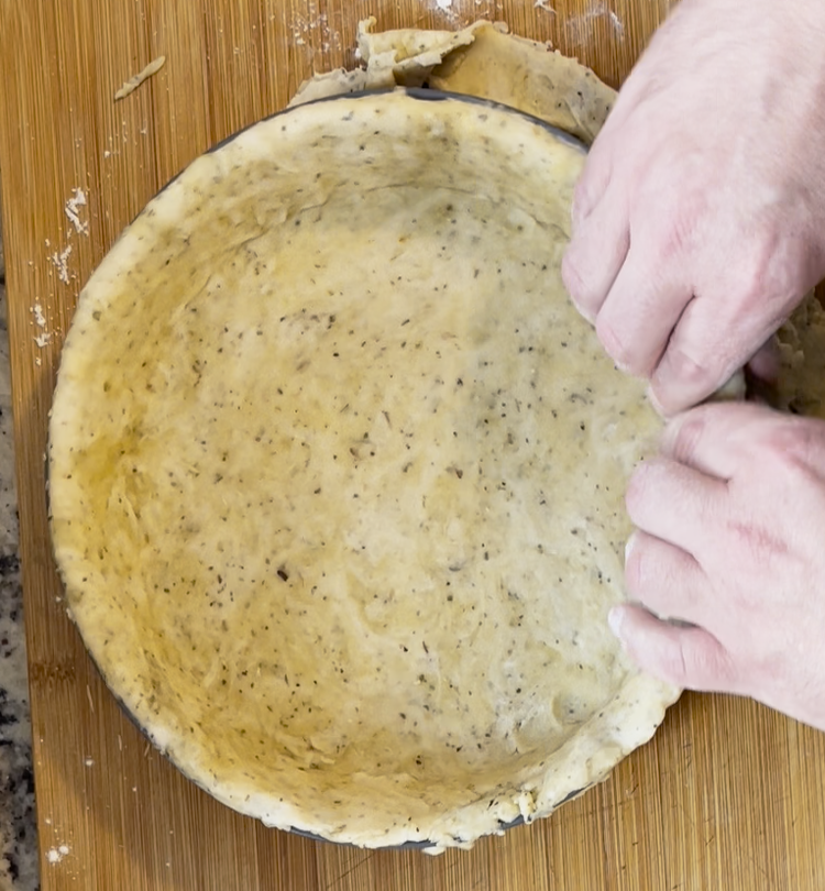 Image of Press the dough into the pie pan and, using a fork, poke holes in the crust to release any steam that is created during cooking.