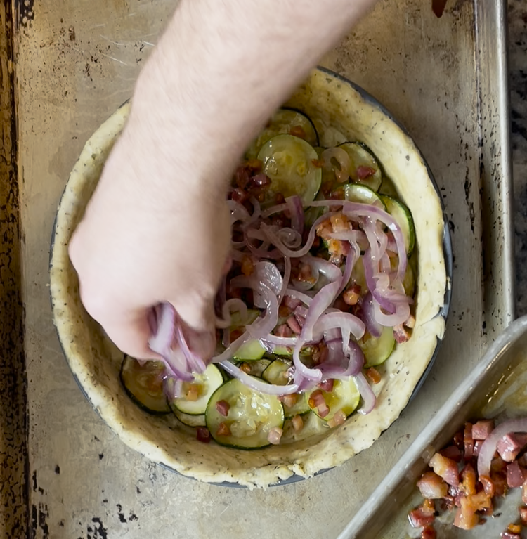 Image of Layer the zucchini, onion and pancetta mixture in the pie crust and pour the custard on top.