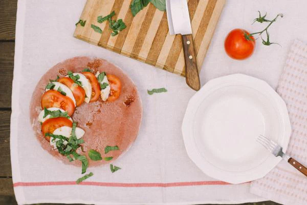 Layered Caprese Salad with Balsamic and Olive Oil on a Salt Block