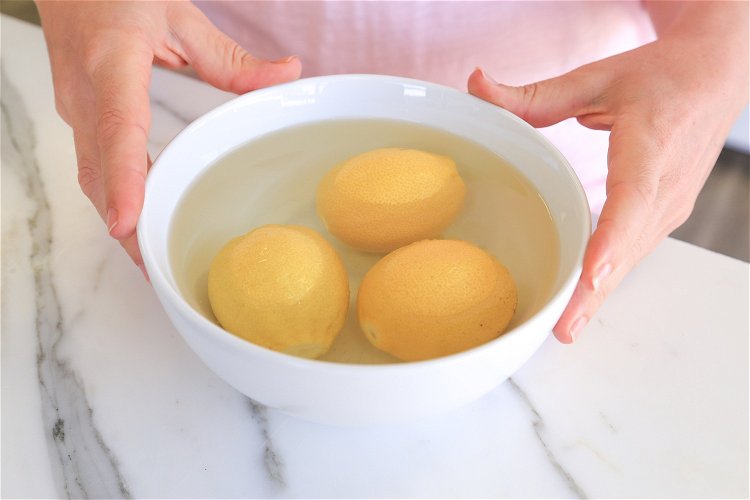 Image of Place the 3 lemons in a microwave-safe bowl covered with...